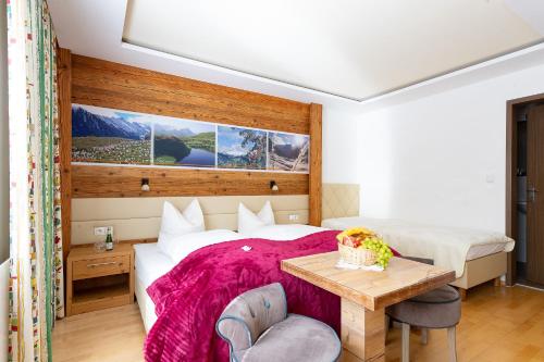 1 dormitorio con 1 cama con manta rosa en Petererhof, en Gerlos