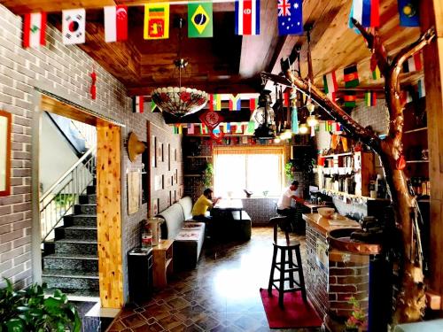 a bar with flags and people sitting in a room at The Silk Road Travelers Hostel in Zhangye