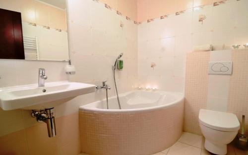 een badkamer met een wastafel, een bad en een toilet bij Eco Friendly Hotel Dália in Košice