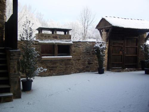 a building with snow on the ground next to a door at Alojamiento Luz de Hadas in Sampil
