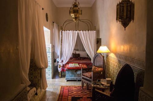 une chambre avec un lit, une table et une lampe dans l'établissement Riad Yamina, à Marrakech