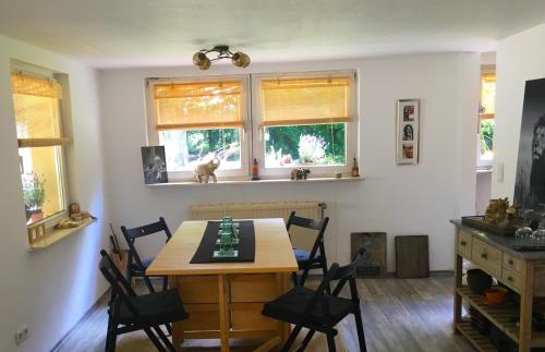 - une salle à manger avec une table, des chaises et des fenêtres dans l'établissement House Apricot, à Krefeld