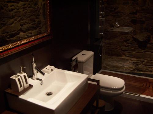 a bathroom with a white sink and a toilet at Alojamiento Luz de Hadas in Sampil