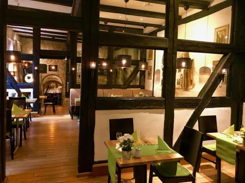 a restaurant with tables and chairs and a large window at Halberstädter Hof in Halberstadt