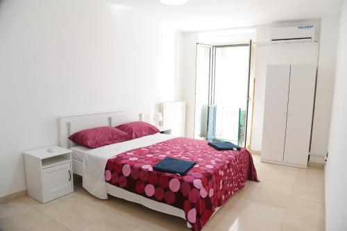 a bedroom with a bed with red and pink sheets at Palazzo Grigio in Bari
