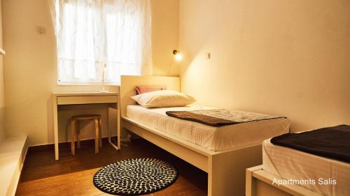 ein kleines Schlafzimmer mit einem Bett und einem Schreibtisch in der Unterkunft Salis Apartments in Vrsi