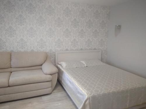 a bedroom with a bed and a couch at Apartment IriS in Baranavichy