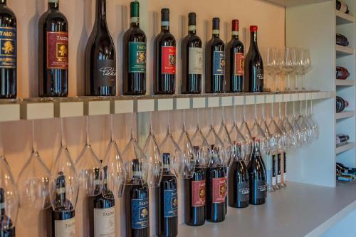 a bunch of wine bottles and glasses on a shelf at Villa Talosa in Montepulciano