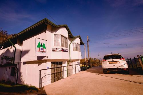 a white car parked in front of a building at Forest View Lodge in Nuwara Eliya
