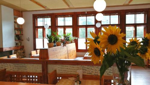 Penzión Manín في بوفاجسكا بيستريتسا: مطعم يوجد به طاولة عليها زهور الشمس