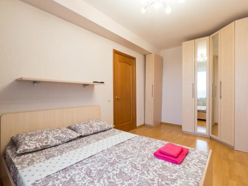 バラシハにあるStig-Realty Center Balashihaのベッドルーム1室(ピンクのタオル付きのベッド1台付)