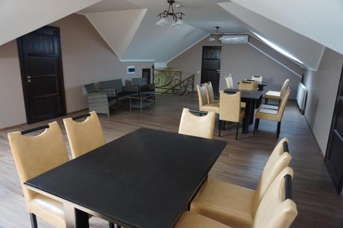 a dining room with a black table and chairs at Hotel Central Park in Velyikyy Bychkiv