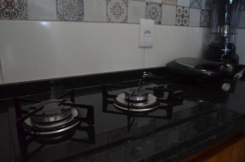 a stove top with two pots on top of it at Residencial Fran Chiattone in Natal