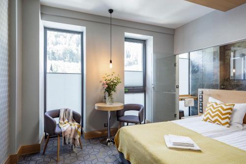 a hotel room with a bed and a table and chairs at Kamieniec 27 Bed & Breakfast in Zakopane