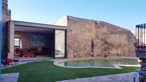 a brick building with a swimming pool in a yard at Castell de Fonolleres in Fonolleres