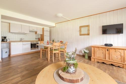 a kitchen and dining room with a table with a vase on it at Haflingerhof - Oberjoch in Bad Hindelang