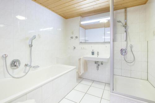 a white bathroom with a tub and a sink at Haflingerhof - Oberjoch in Bad Hindelang