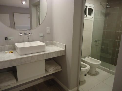 uma casa de banho com um lavatório, um WC e um espelho. em Cala hotel boutique em San Luis