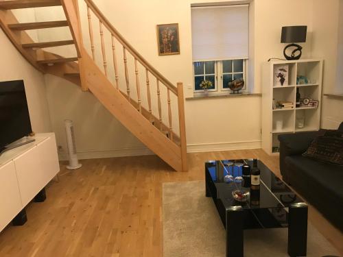 a living room with a staircase and a couch at Centralt i Gentofte i 2 plan, ved S-Tog og busser in Gentofte