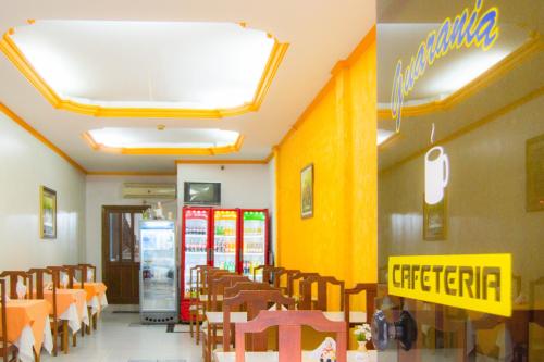 a restaurant with tables and chairs and a yellow wall at Hotel & Restaurante Guarania in Ciudad del Este
