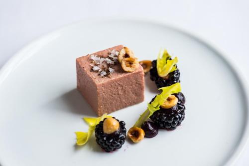 a chocolate dessert with blackberries and nuts on a plate at Hart's Hotel in Nottingham