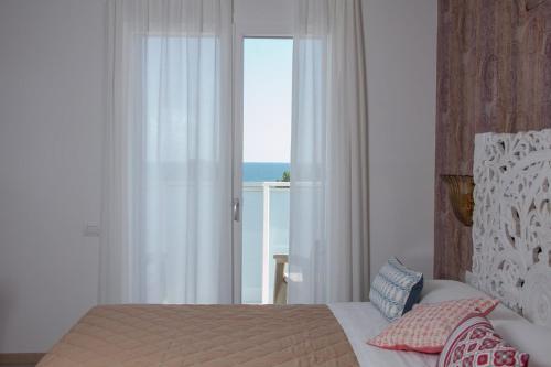 a bedroom with a bed with a view of the ocean at Hotel Albatros 3 Stelle Superior in Lido di Jesolo