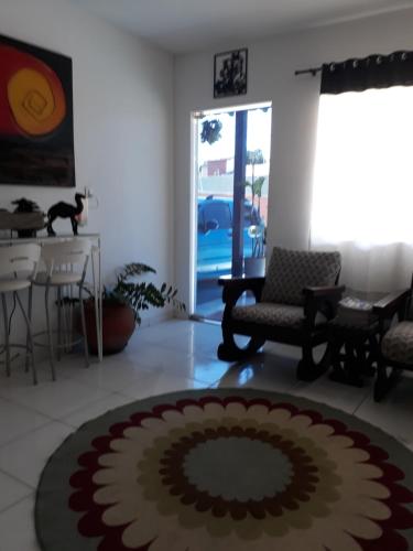a living room with a large rug on the floor at Pousada Solar dos Cavaleiros Mendes in Macaé