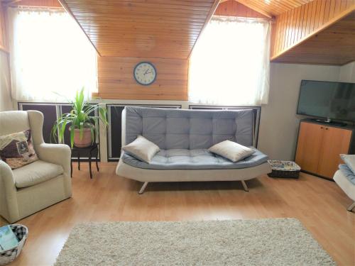 sala de estar con sofá y reloj en la pared en Comfy roof with terrace - 4 TH FLOOR WITHOUT LIFT-1 Air Conditioner, en Denizli
