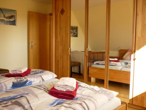 a bedroom with two beds and a mirror at Ferienhaus Kozian in Kühlungsborn