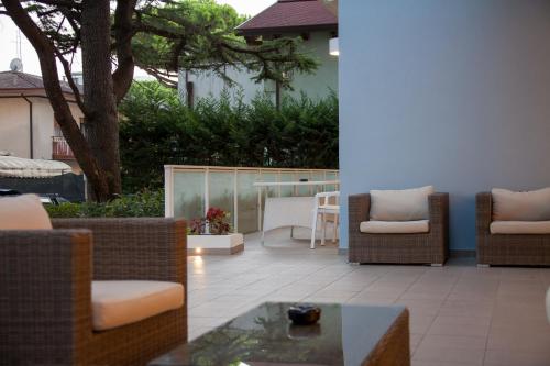 a patio with wicker chairs and a table at Hotel Albatros 3 Stelle Superior in Lido di Jesolo