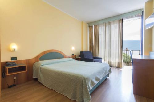 ガルニャーノにあるHotel Lidoのベッドとバルコニー付きのホテルルーム