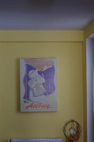 a picture on a yellow wall with a poster on it at Haus Fallesin in Sankt Anton am Arlberg
