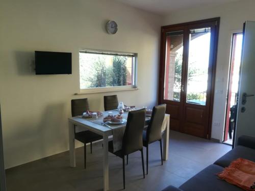 a dining room with a table and chairs and a television at Tulipano Appartamenti in Marotta