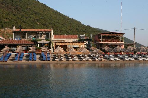 a beach with chairs and umbrellas next to the water at Apartments Boss in Budva