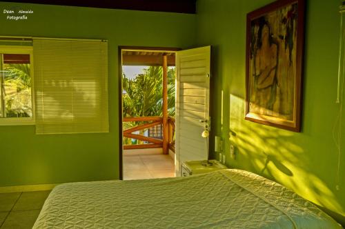 a bedroom with green walls and a bed in it at Casa de beira mar com piscina in Coruripe