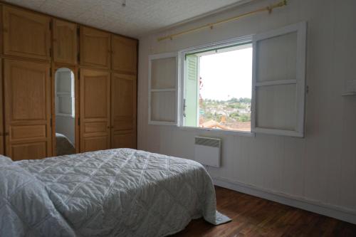 a bedroom with a bed and a window at Ivy house in LʼIsle-Jourdain
