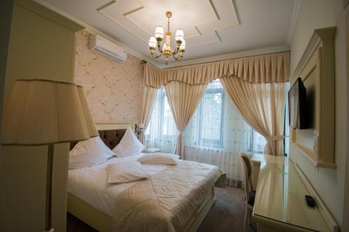 a bedroom with a bed and a chandelier at Boutique Tosca Regal in Bacău