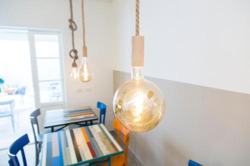 una luz colgante de cristal colgada sobre una mesa con libros en Il Battello, en Cesenatico