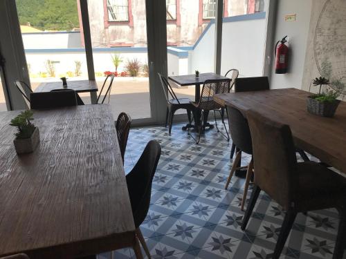 a restaurant with wooden tables and chairs and a floor with stars at Royal Beach Hostel in Praia da Vitória