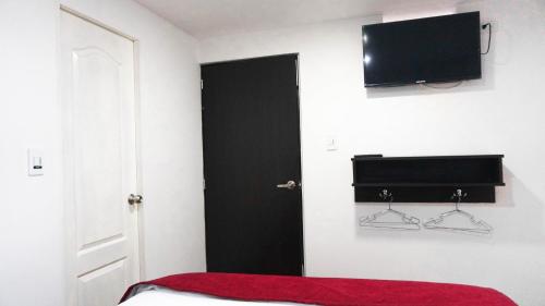 una camera con un letto e una televisione a muro di Hotel Funza Real a Funza