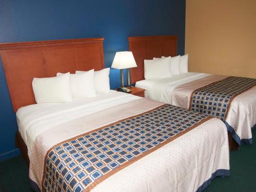 two beds sitting next to each other in a room at Swiss Chalets Village Inn in North Conway