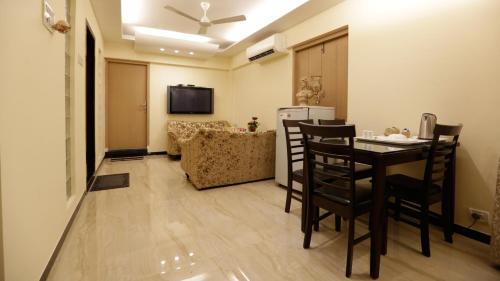 a living room with a table and chairs in a room at Hotel Metro Palace Bandra in Mumbai