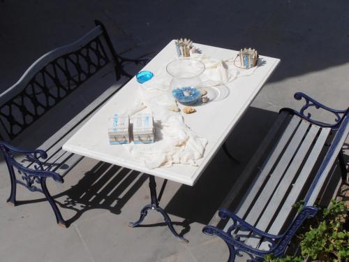 a white table with two benches and a table with plates at Panorama in Skafidia