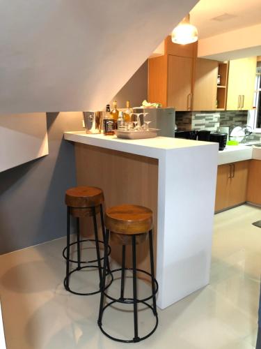 a kitchen with two stools at a kitchen counter at *3BR/*3Bath Fully Furnished Town House - BICOL in Naga