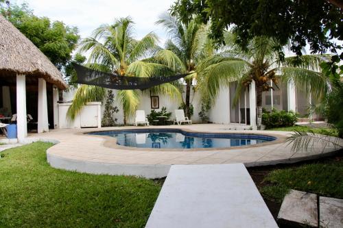 a pool in the backyard of a house with palm trees at Casa San José in El Conacaste