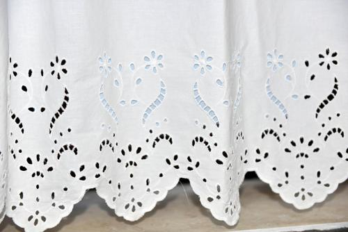 a white shower curtain with flowers on it at Evagelia's deluxe villa-Roof Top Jacuzzi in Skopelos Town