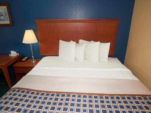 a bedroom with a bed with a wooden headboard at Swiss Chalets Village Inn in North Conway