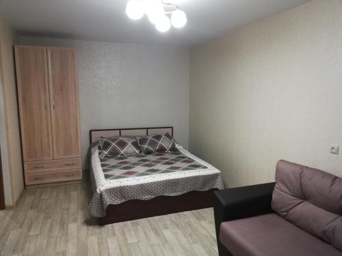 ノヴォシビルスクにあるApartment Finika5 m. Rechnoj Vokzalの小さなベッドルーム(ベッド1台、ソファ付)