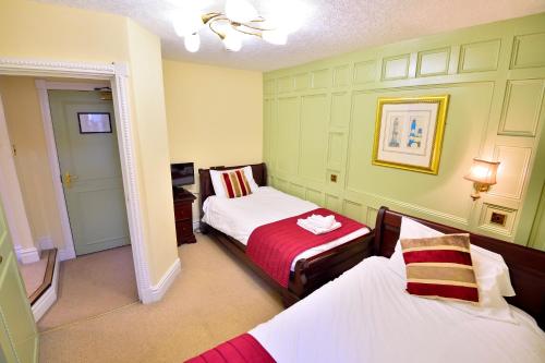 a small room with two beds and a hallway at The Angel Hotel in Coleford