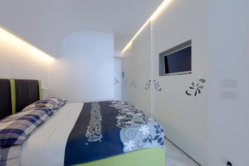 sypialnia z łóżkiem i telewizorem na ścianie w obiekcie Boutique House Fiò w mieście Ischia